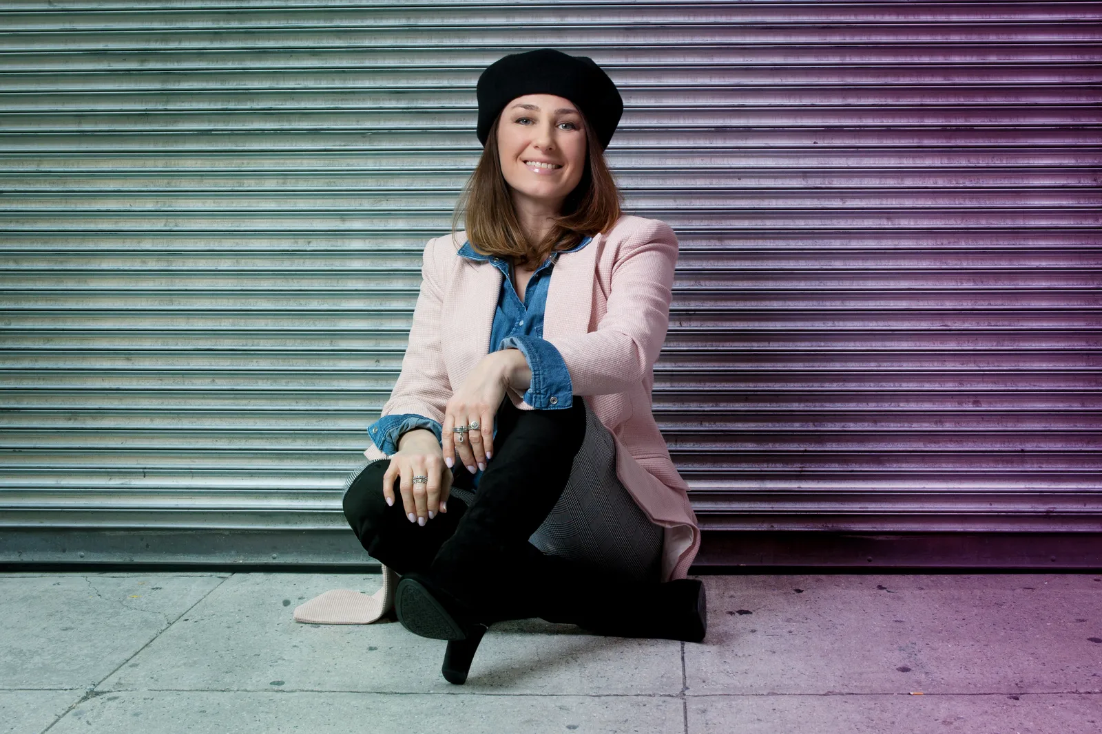 Martyna im rosa Blazer vor einem farbigen Rolltor